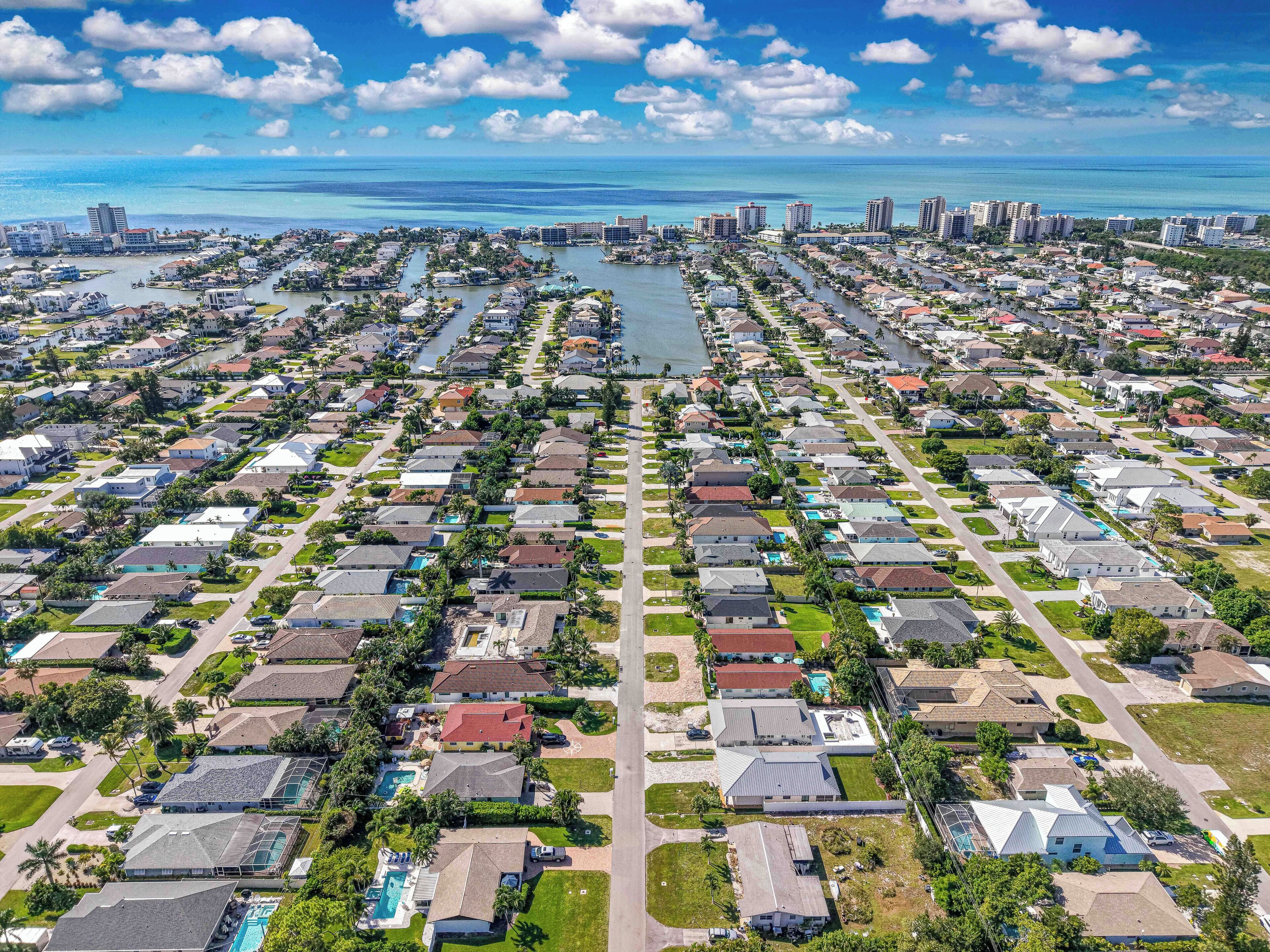 An aerial view of a residential area with houses, streets, and a marina.