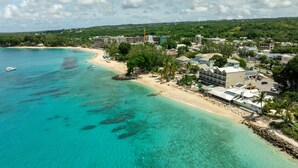 A coastal resort with beachfront accommodations, clear turquoise waters, and a mix of modern and traditional architecture. - Villas On The Beach 305 2 Bedroom Home (Holetown)