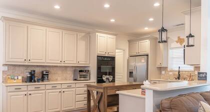 Modern country comfort in this 4-bedroom Anna retreat near McKinney. Sleeps 12 with open layout, full kitchen, foosball, and covered patio with BBQ. Rustic Texas charm with modern amenities — perfect for family or group getaways.