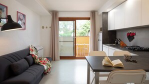 Eine moderne Küche mit Essbereich, einer Couch und einem großen Fenster.