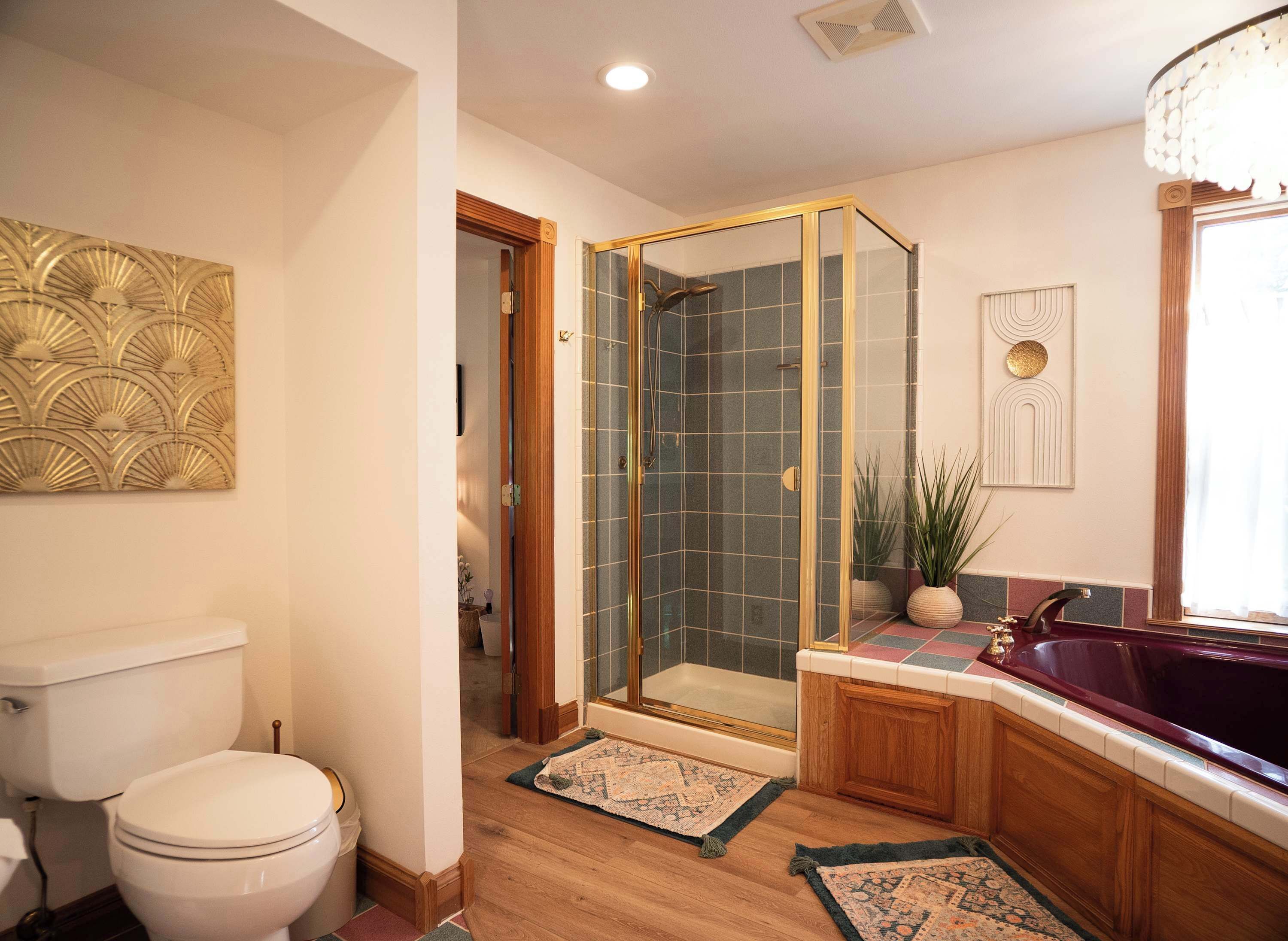A bathroom with a toilet, a shower with a glass door, a bathtub, and a sink with a mirror.