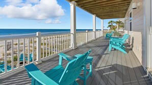 A wooden deck with turquoise Adirondack chairs overlooking a beach. - Siren's Song - Beach front, Private Pool, Island Luxury! (St. George Island)