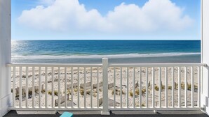 A beach view from a balcony with white railings, sandy beach, and ocean. - Siren's Song - Beach front, Private Pool, Island Luxury! (St. George Island)