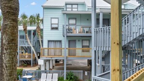 Un immeuble à plusieurs étages doté de balcons, d’un espace extérieur aménagé pour s’asseoir et d’une zone avec piscine.