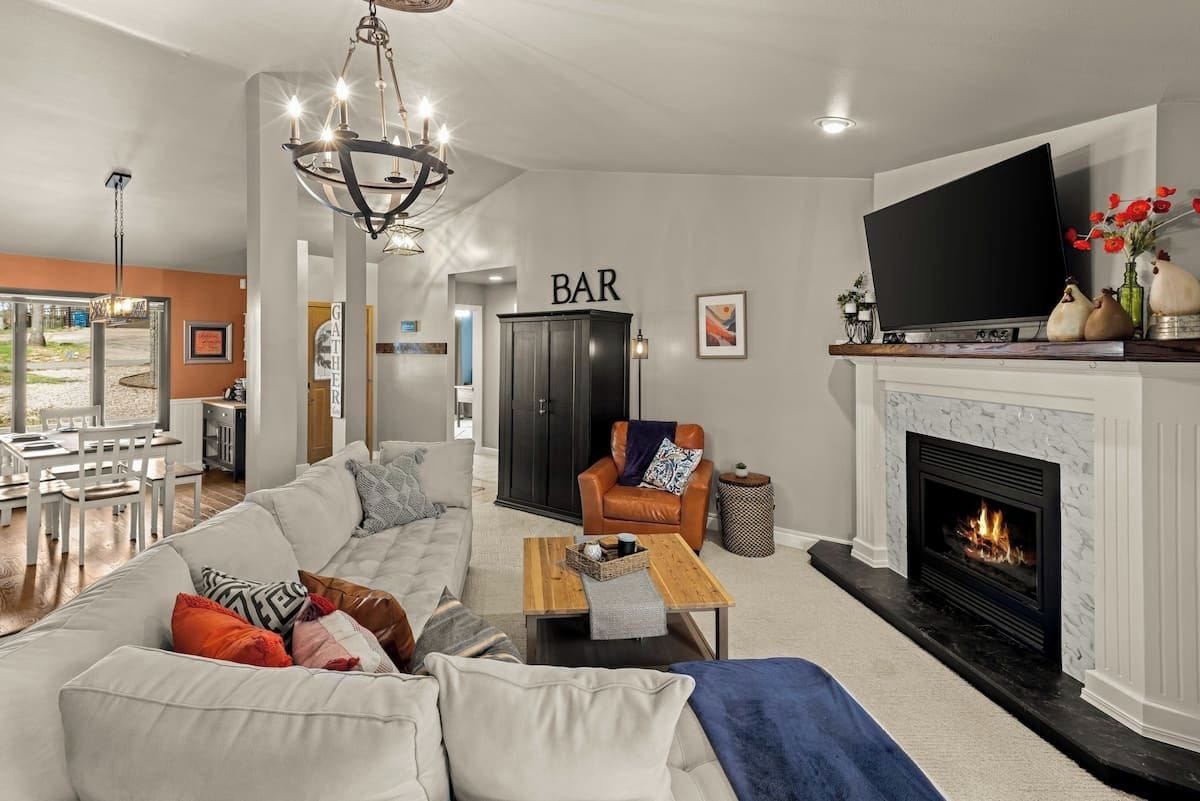 Ein modernes Wohnzimmer mit einer Couch, einem Couchtisch, einem Kamin, einem Fernseher und einer Bar.