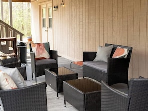 An outdoor seating area with wicker furniture and a wooden wall. - Bella Vista Retreat sleeps 8 | Game Room + Trails (Bella Vista)