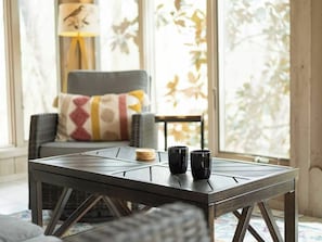 A room with a table, two black cups, a cushion, and a lamp. - Bella Vista Retreat sleeps 8 | Game Room + Trails (Bella Vista)