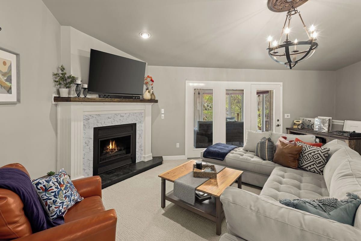 A living room with a fireplace, a television, a sofa, and a coffee table.