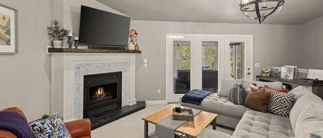 A living room with a fireplace, a television, a sofa, and a coffee table.