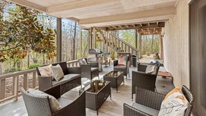 Un espace extérieur aménagé, abrité et doté de mobilier en osier et d’un barbecue.