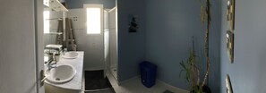 Une salle de bain avec deux lavabos, un miroir et une fenêtre.