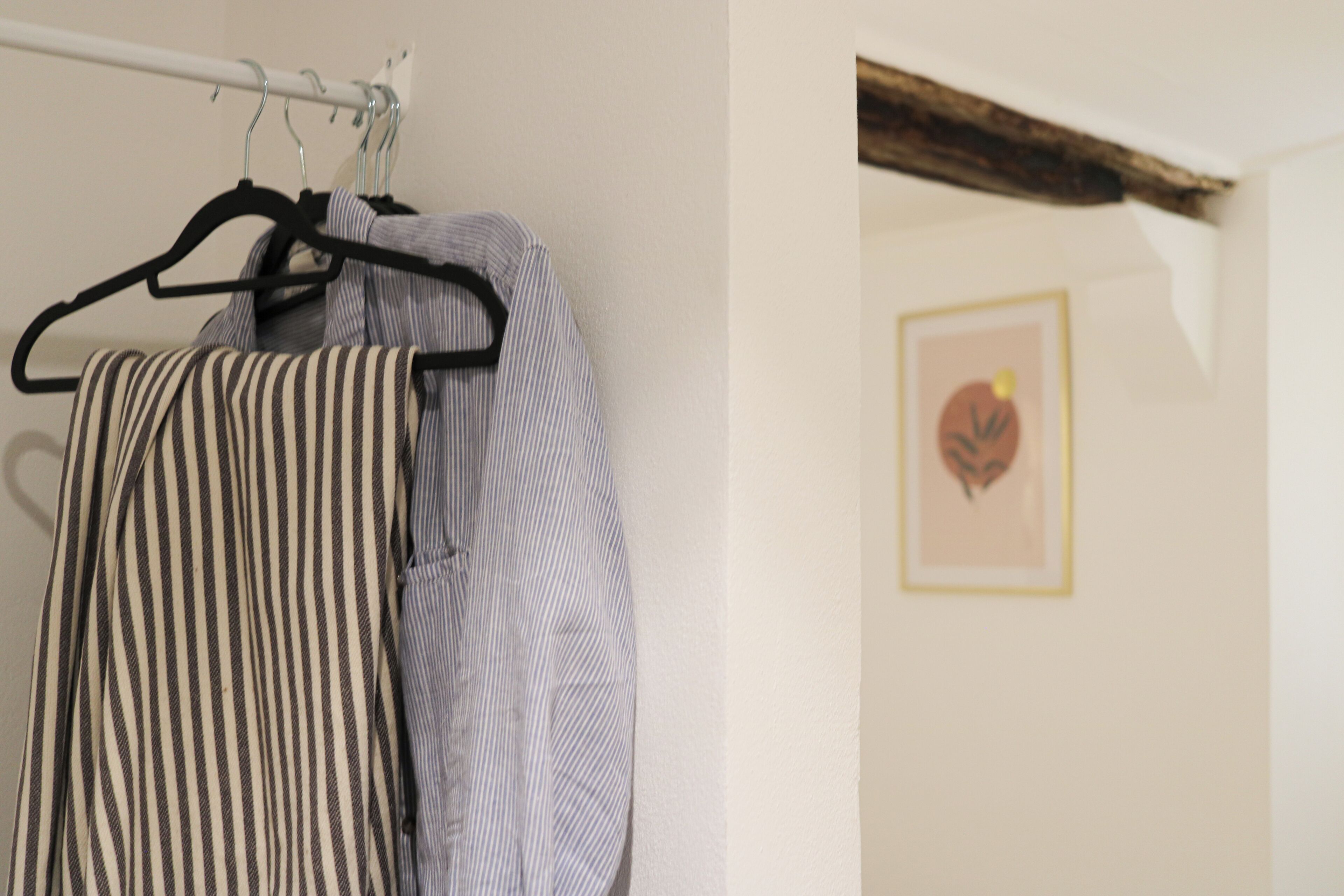 Un portant à vêtements avec des vêtements à rayures.