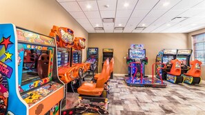 Un salón de juegos interior con varias máquinas de carreras y zonas de estar.