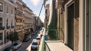 A balcony with a view of a street lined with parked cars and buildings. - Acropolis Oasis - 2BR, Koukaki (Athina)