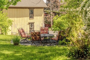 Une maison dotée d’un patio comprenant une table et quatre chaises.