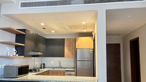 Eine moderne Küche mit Granit Arbeitsplatte, Edelstahlgeräten und einer Mischung aus dunklen und hellen Schränken.