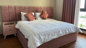 Ein Schlafzimmer mit einem Bett, einem Nachttisch und einem Fenster mit Vorhängen.
