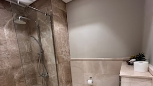 Ein modernes Badezimmer mit einer Duschkabine, einer weißen Badewanne und einem WC.