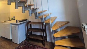A modern kitchen with a built-in refrigerator, a sink, and a wooden dining table. - Steps to Duomo: Historic Florence Studio (Florence)