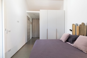 Un dormitorio con cama, armario y cabecero de listones de madera.