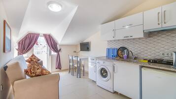 Apartment, Courtyard View, Garden Area | Private kitchen | Mini-fridge, stovetop, highchair, cookware/dishes/utensils