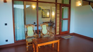 A room with a wooden table and two chairs, a sliding glass door, and a staircase. - Jade Ella (Ella)