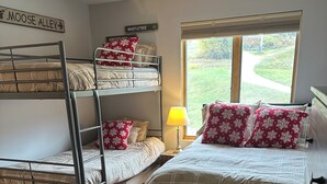 A dormitory room with bunk beds, a window with a view of a green landscape, and a sign on the wall indicating "Moose Alley". - One Bedroom Ski-In/Ski-Out Condo on Whiffletree Chairlift. Short Walk to Village (Carrabassett Valley)