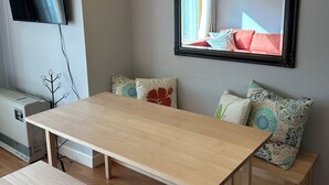 A modern living room with a wooden table, bench, and a ceiling light fixture. - One Bedroom Ski-In/Ski-Out Condo on Whiffletree Chairlift. Short Walk to Village (Carrabassett Valley)