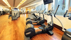 A gym with treadmills, elliptical machines, and weight machines. - PVH - 1BR - Emaar Fashion Avenue (Dubai)