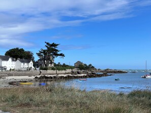 A coastal scene with houses, a rocky shoreline, and boats in the water. - In a haven of peace, charming house, 5 minutes from white sandy beaches (Plounéour-Brignogan-plages)