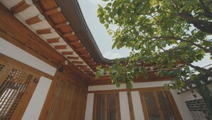 Une pièce de style japonais traditionnel, avec des poutres en bois, un sol recouvert de tatamis et des paravents en papier de riz (shoji).