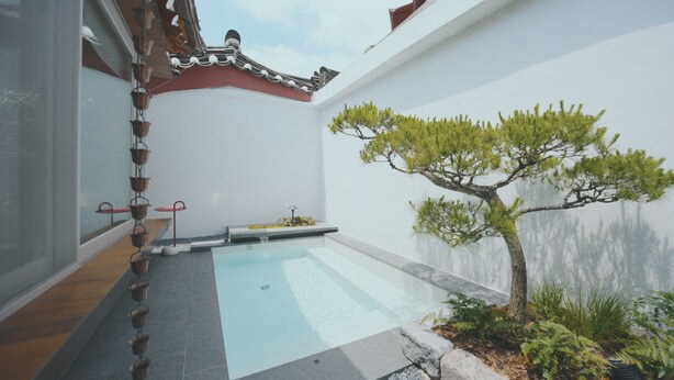 Un jardin de style japonais traditionnel, avec un bassin à carpes koï, un petit arbre et une lanterne en pierre.