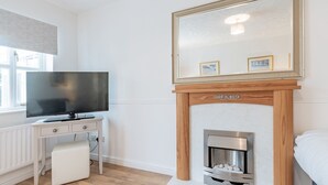 A modern bedroom with a television, a fireplace, and a large mirror. - Pass the Keys | Cosy home | Basildon | Ideal for contractors (Basildon)