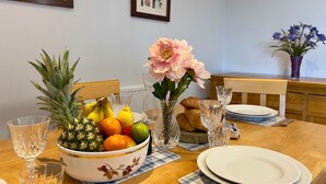 A dining table set with a fruit bowl, flowers, and glassware. - Pass the Keys |Modern Penthouse Style Apartment in Haddenham (Aylesbury)