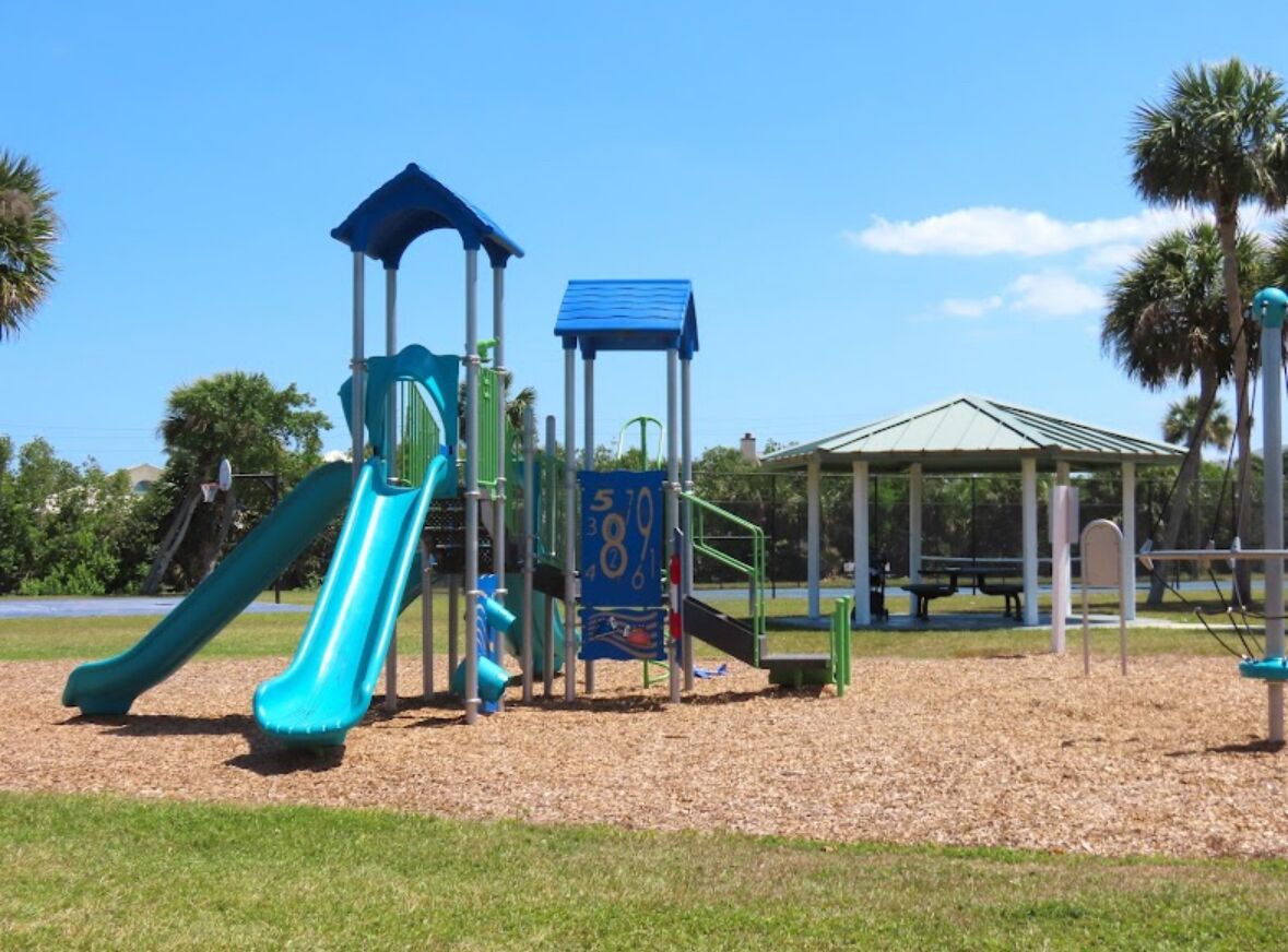 Un parc infantil amb tobogan, elements per escalar i una glorieta.