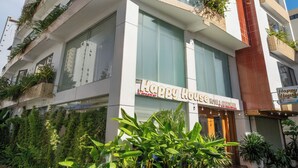 A multi-story hotel with balconies, large windows, and a sign reading "Happy House Hotel & Restaurant". - Happy House Hotel & Apartment (Da Nang)