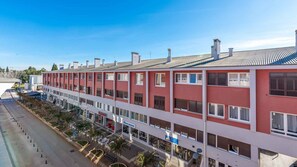 A multi-story building with a red facade, multiple windows, and a flat roof. - Holiday apartment with air conditioning and sea view (Umag)