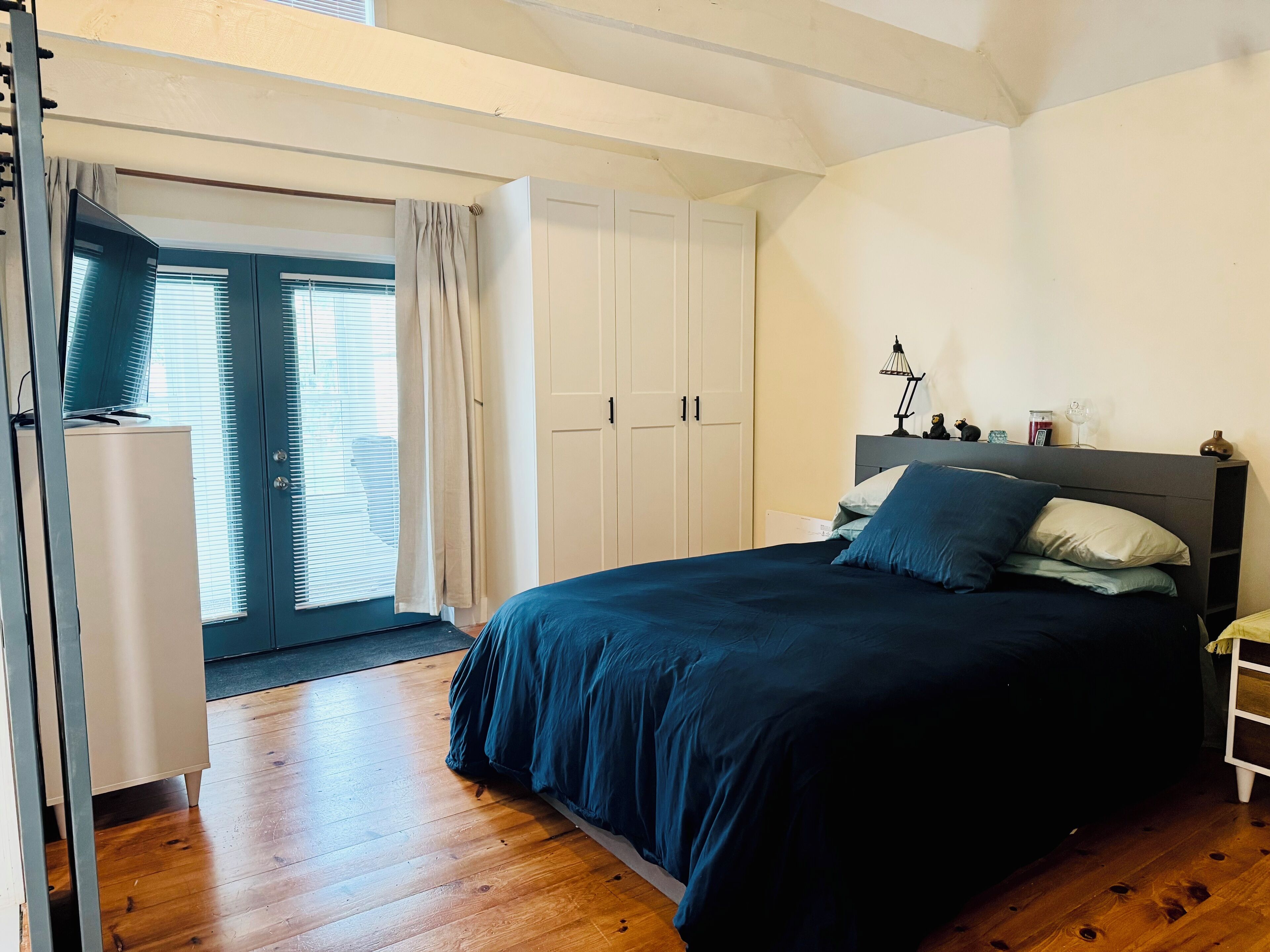 Een slaapkamer met een groot bed, een garderobe en een bureau.