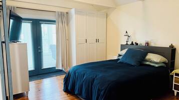 Een slaapkamer met een groot bed, een garderobe en een bureau.