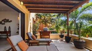 A covered outdoor seating area with wooden furniture and potted plants. - Pelicano. Beachfront 2 floor condo in Bucerias (Bucerías)