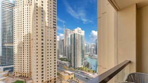 Un edificio de gran altura con piscina y vista al río y otros edificios.
