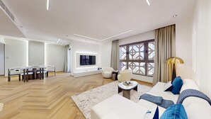 Una sala de estar moderna con sofá, mesa de centro y comedor con mesa y sillas.