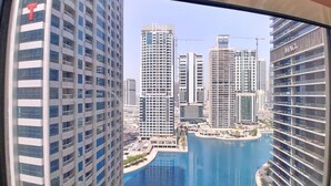 A high-rise building with a view of a marina and other high-rise buildings.