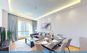Una sala de estar moderna con comedor, ventanas amplias y un televisor de pantalla plana.