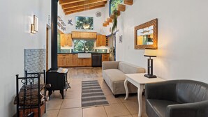 A cozy living room with a fireplace, a sofa, a table, and a lamp.