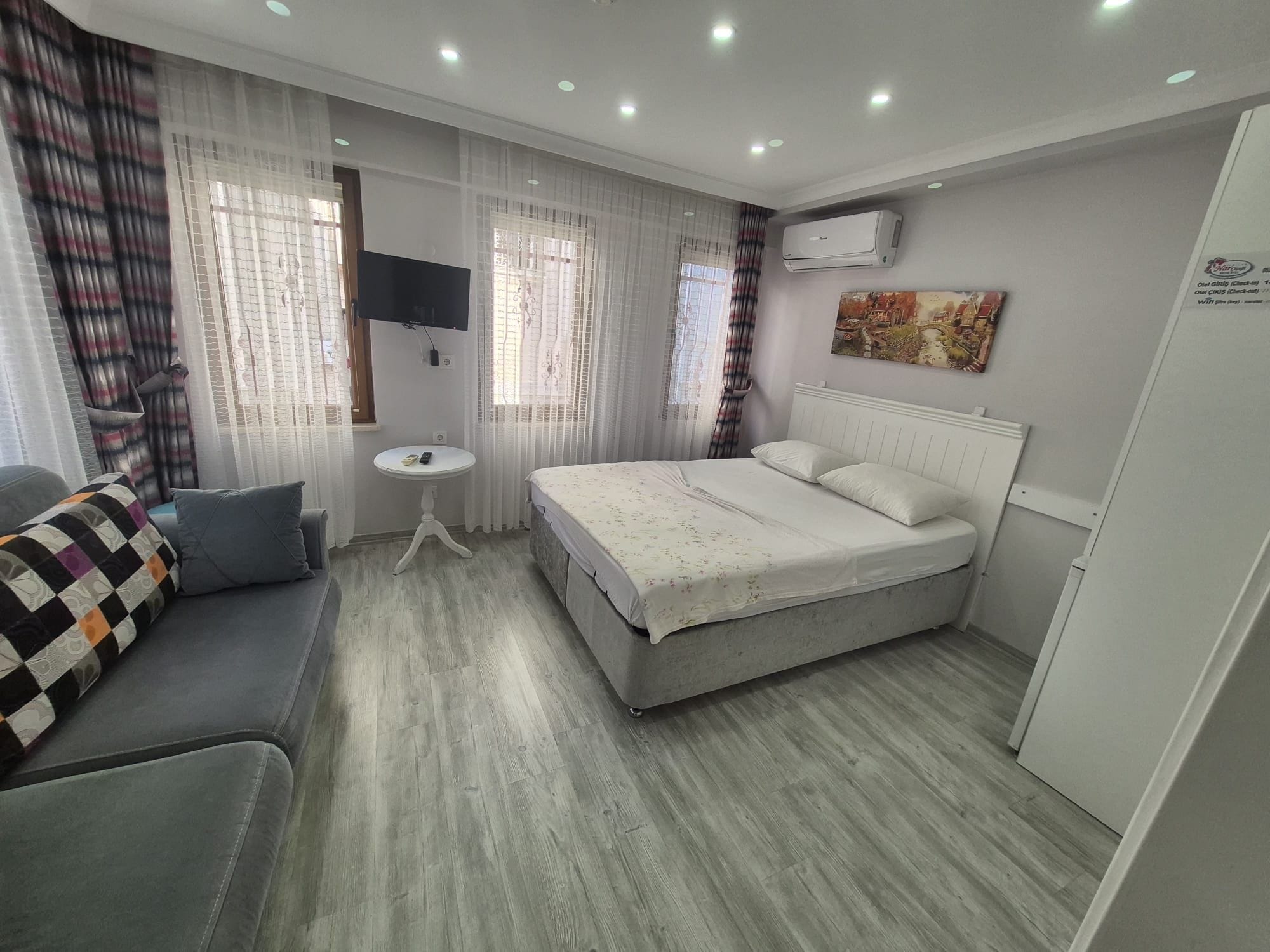 Une chambre d’h ôtel équipée d’un lit, d’un canapé, d’une petite table, d’une télévision et d’un appareil de climatisation.