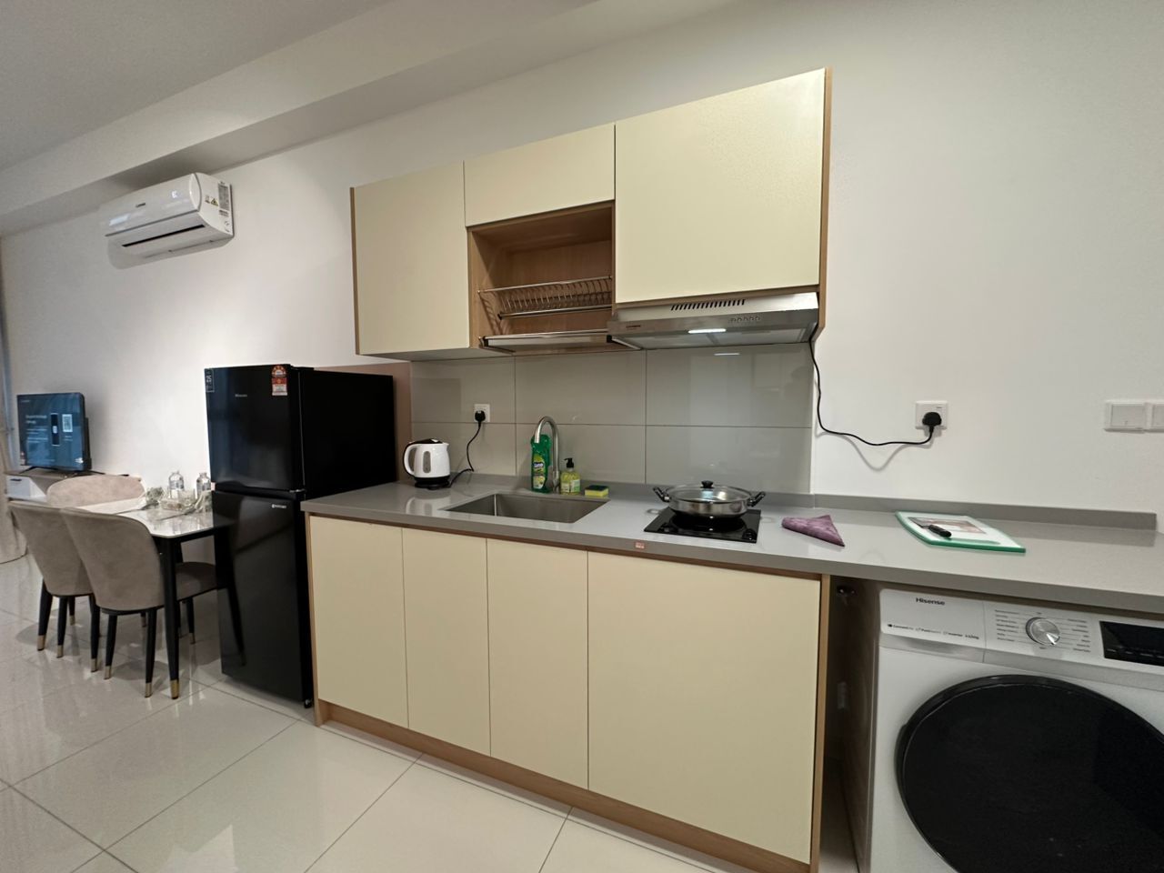 A modern kitchen with a built-in dishwasher, a stove, and a sink. There is a dining area with chairs and a table.