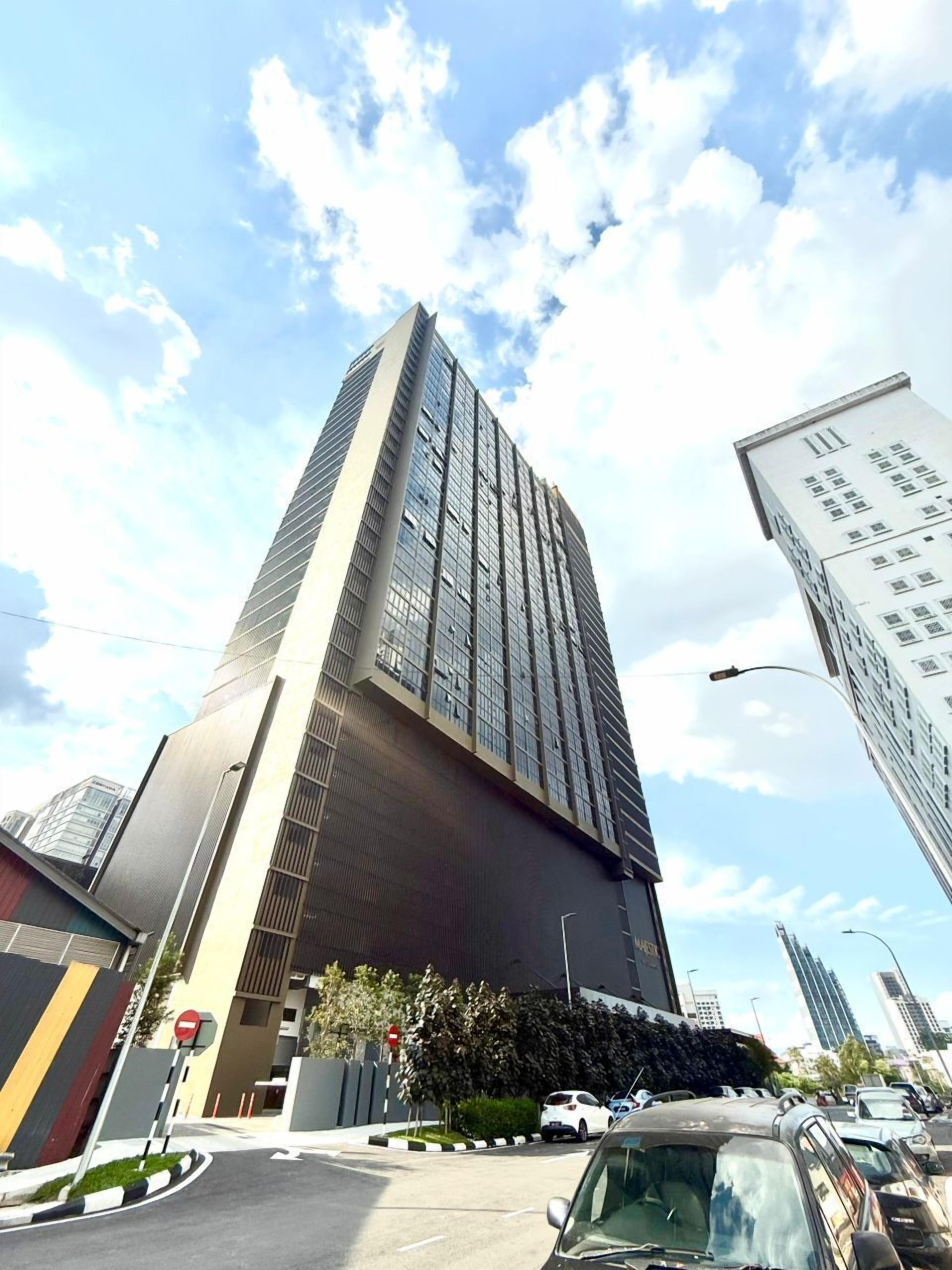A tall, modern building with a prominent glass facade and a unique angular design.