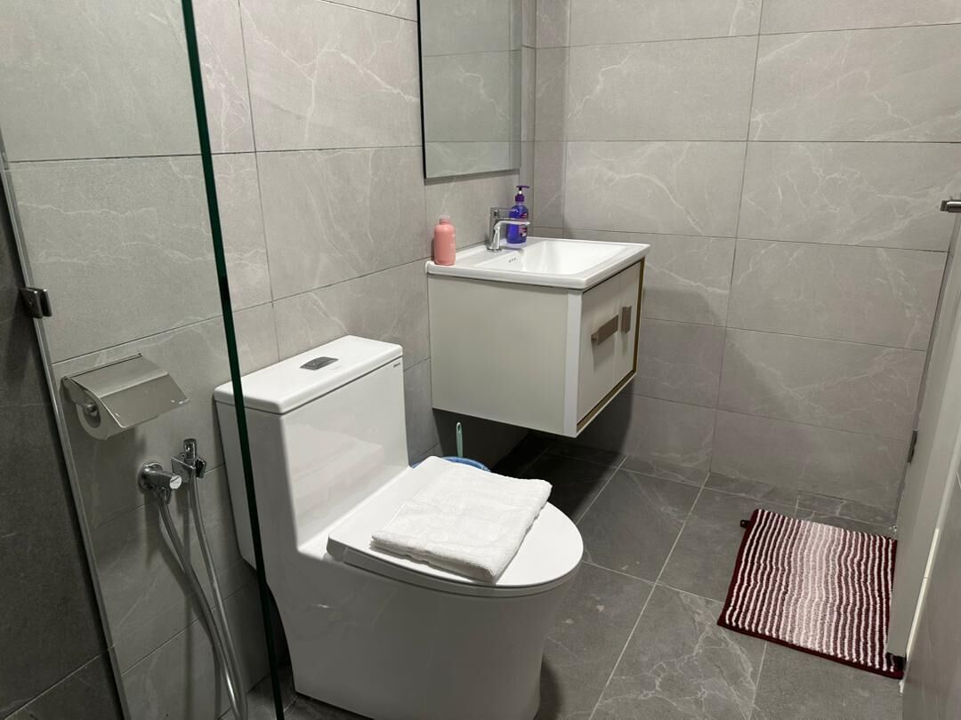 Une salle de bain moderne équipée de toilettes, d’un lavabo et d’une douche.