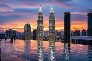 A cityscape with two prominent skyscrapers, a modern bridge, and a waterfront promenade. - Majestic Residence KLCC By My HOME (Kuala Lumpur)